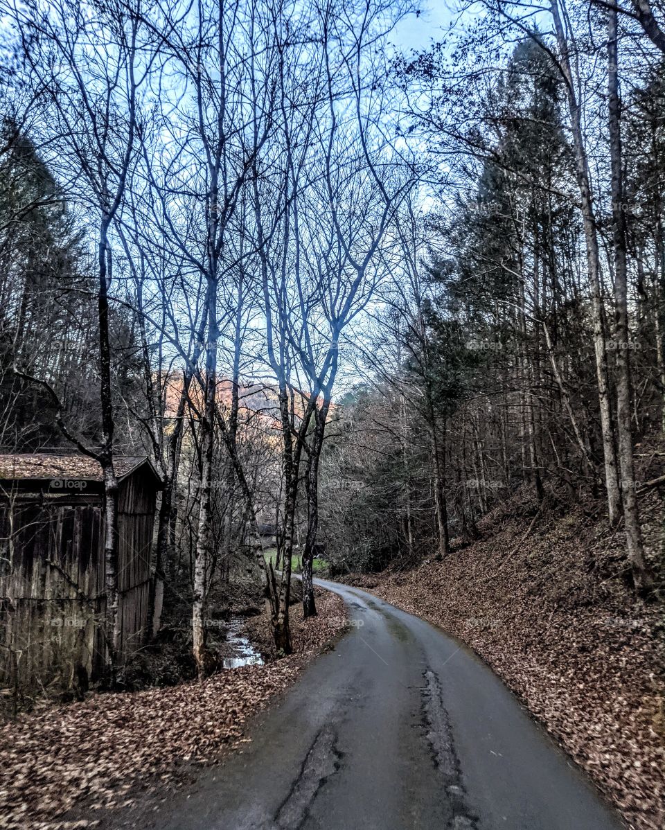 old barn on the side of a narrow country road in the mountains of east tennessee