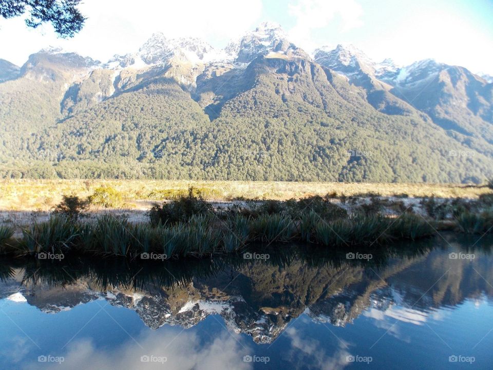 Snow capped mountains reflected in a clear pool
