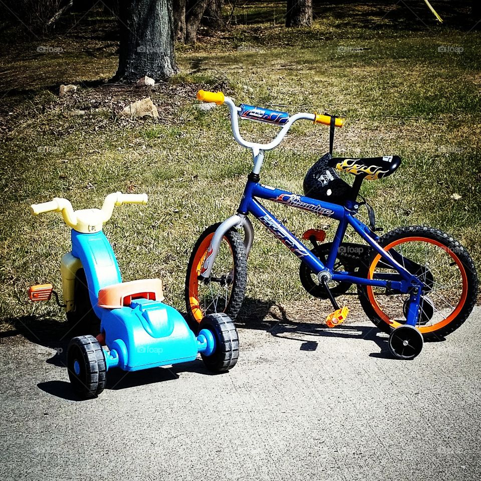 childrens bikes. busy day playing outside.  toys left out in the driveway