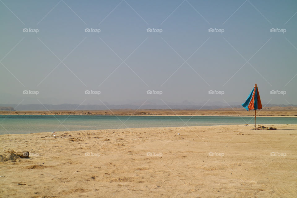 Lonely umbrella on Sharm El Luli beach in egypt near Marsa Alam