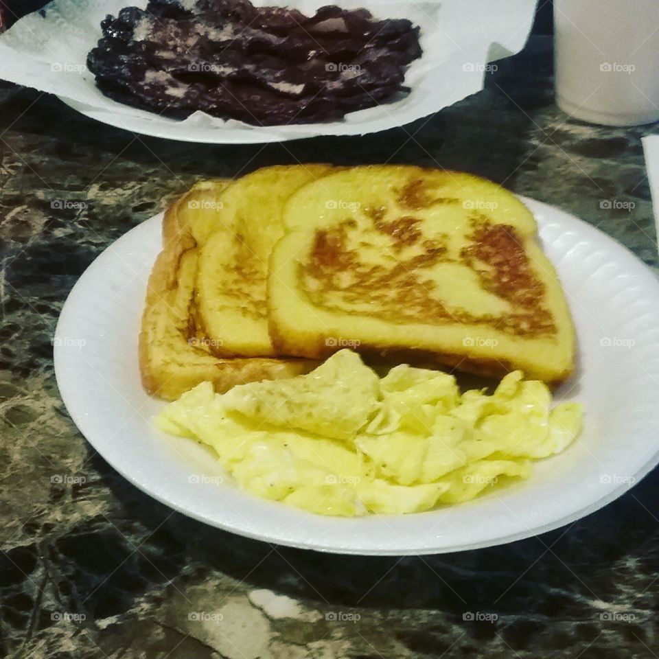 French toast and bacon and scrambled eggs though the bacon looks a little dark lol
