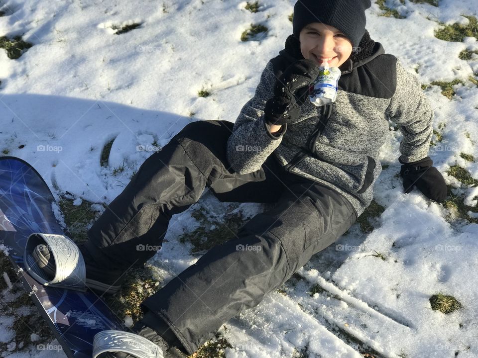 Boy with snowboard enjoying buddy fruits 