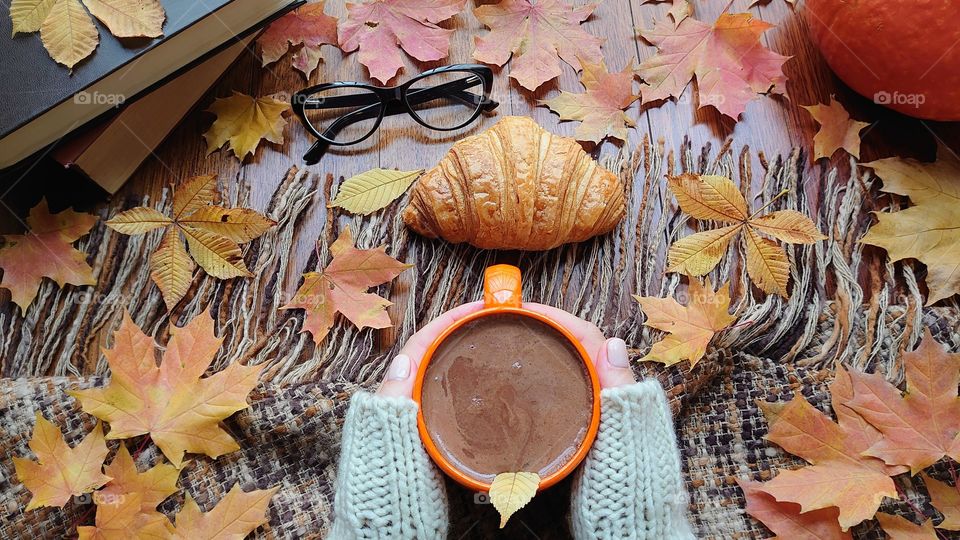 Hot chocolate time! It's autumn time! Plaid with tassels, a mug of hot chocolate in hands, pumpkin, books, glasses and autumn mood 🍁🍂