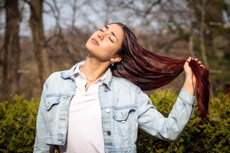 Young woman with a long hair is sunbathing