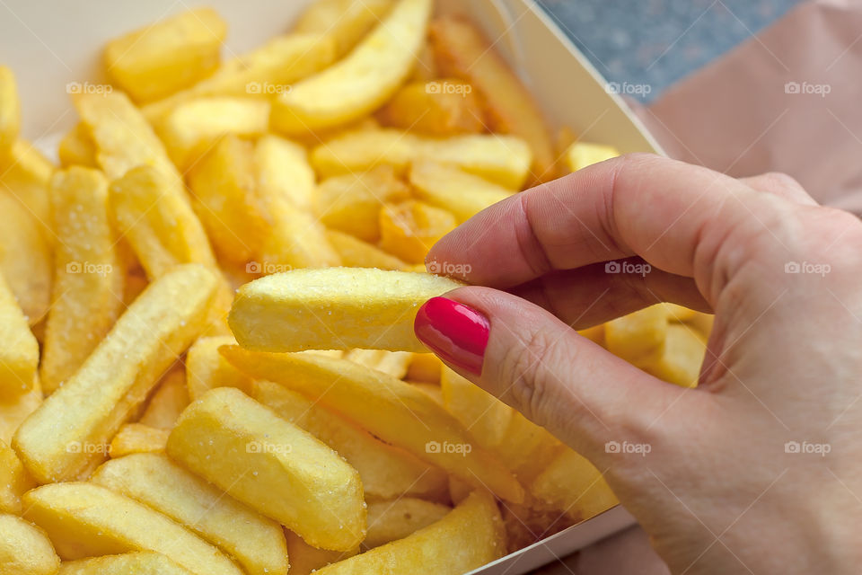 woman's hand taking potato fried chips