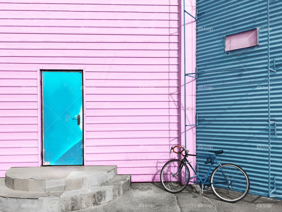 Bicycle on pink and blue wall background 