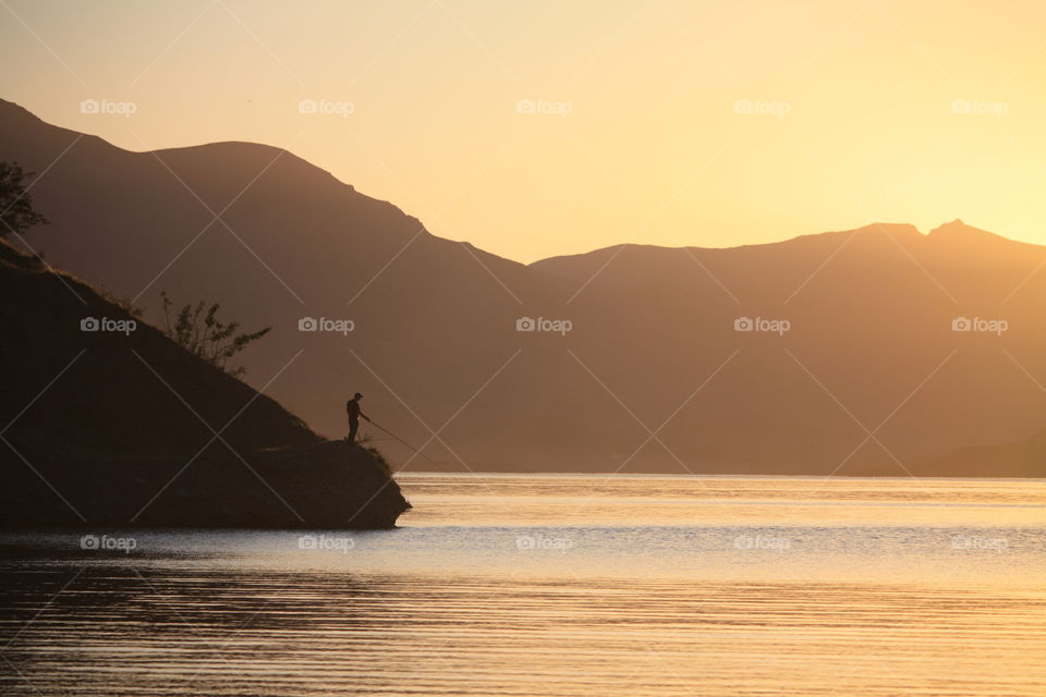 Taleghan lake in sunset and a man who fishing in peace