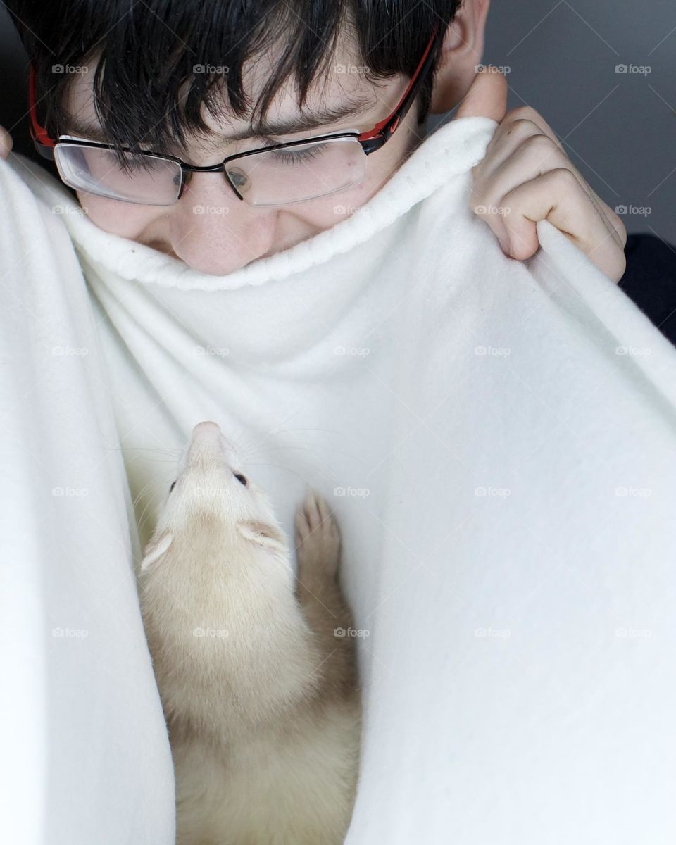 Ferret playing peek a boo with his best friend