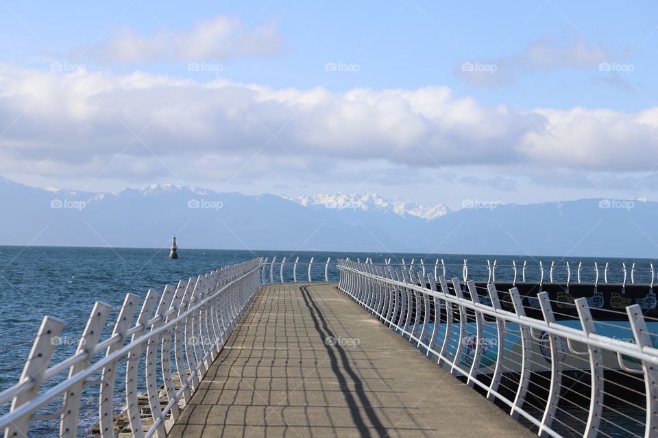 Shadow of metallic fence on breakwater 