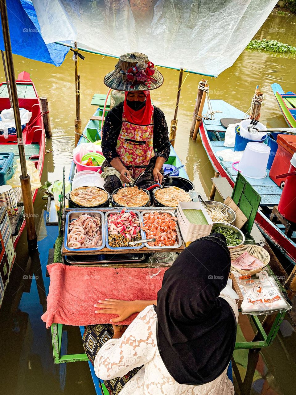 A woman selling food at the floating market in Thailand 