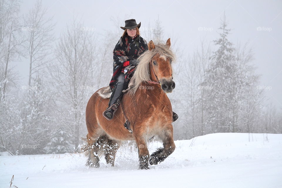 Woman riding on horse in winter