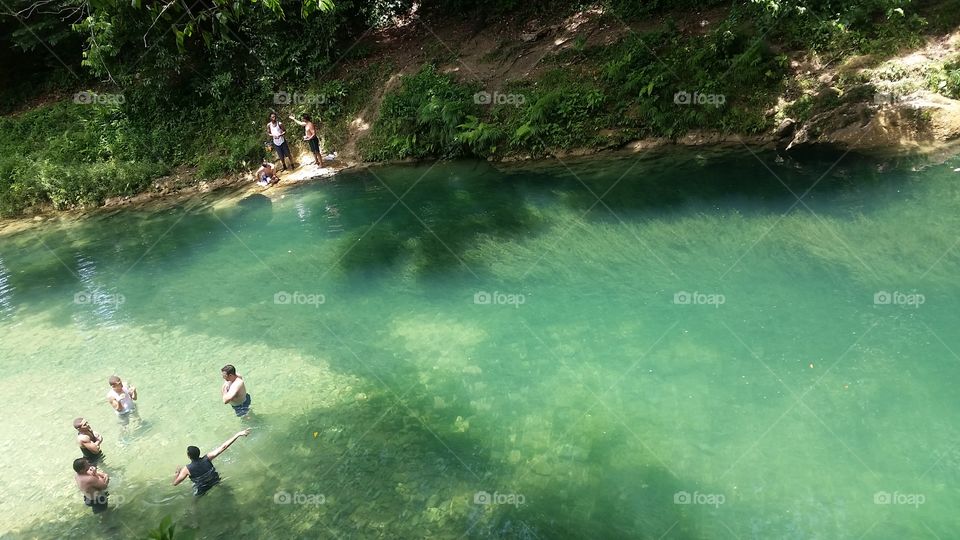 people enjoying emerald green river in Dominican Republic.