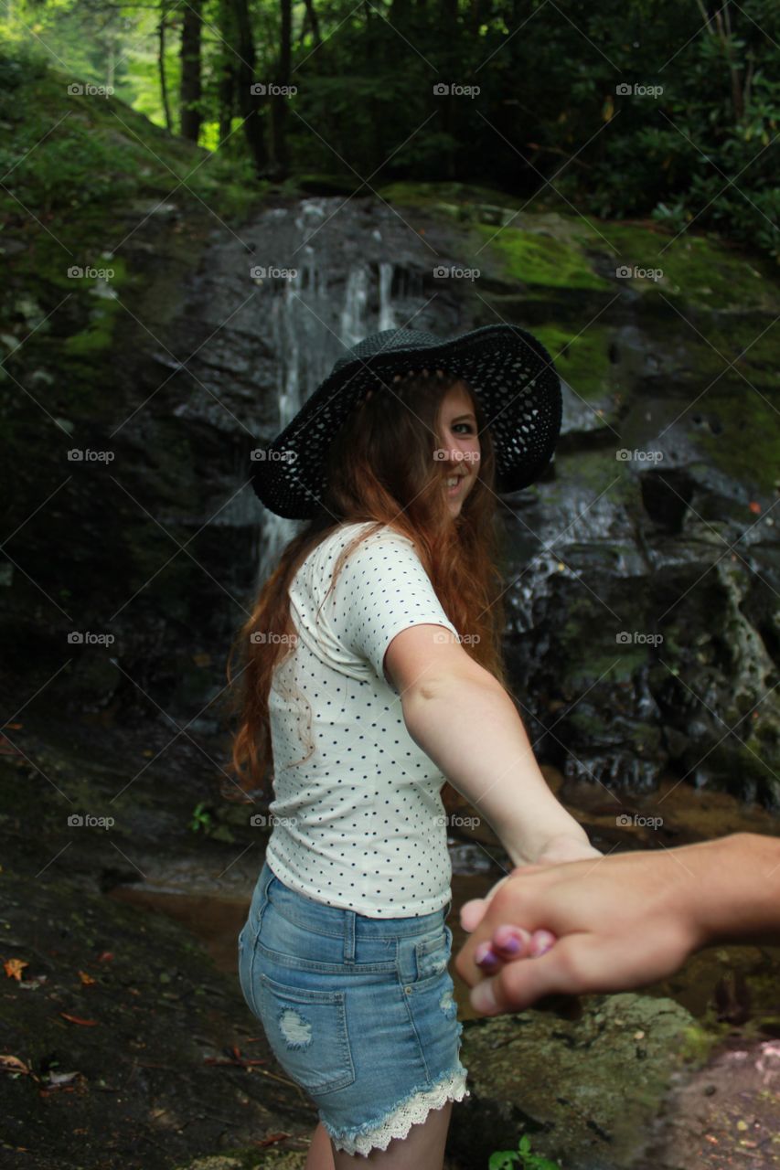 Woman standing in front of waterfall