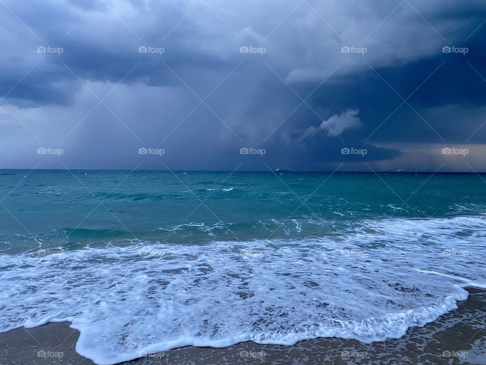 Storm clouds moving in over a beach at sunset