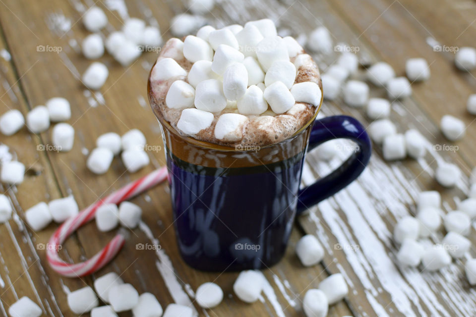 A mug of hot chocolate topped with marshmallows and peppermint