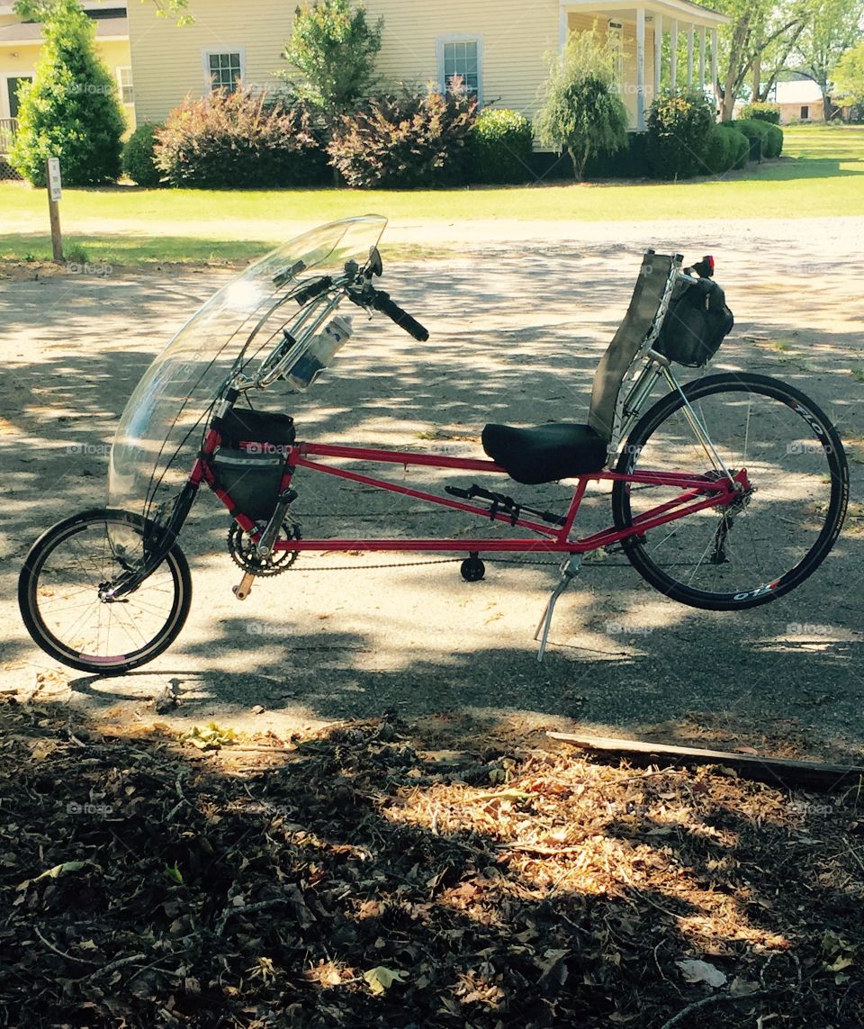 A bicycle  outdoors used in bike racing where one reclines while racing.
