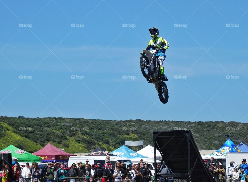 Motorcycle Stunt. Expert Rider Jumping A Motorcycle Off A Ramp
