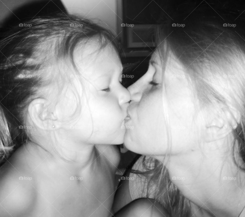 Mother and daughter kisses