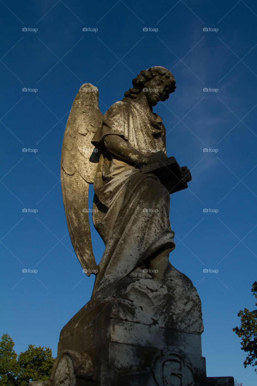 grave stone angel. sculpture watching over a cemetery