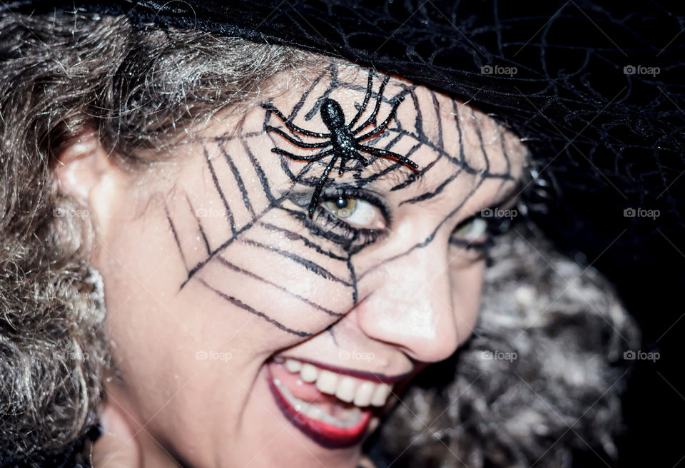 Fake spider on tattoo over the woman's face