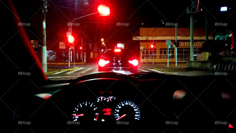 Em trânsito, noturno. Luzes, semáforos.