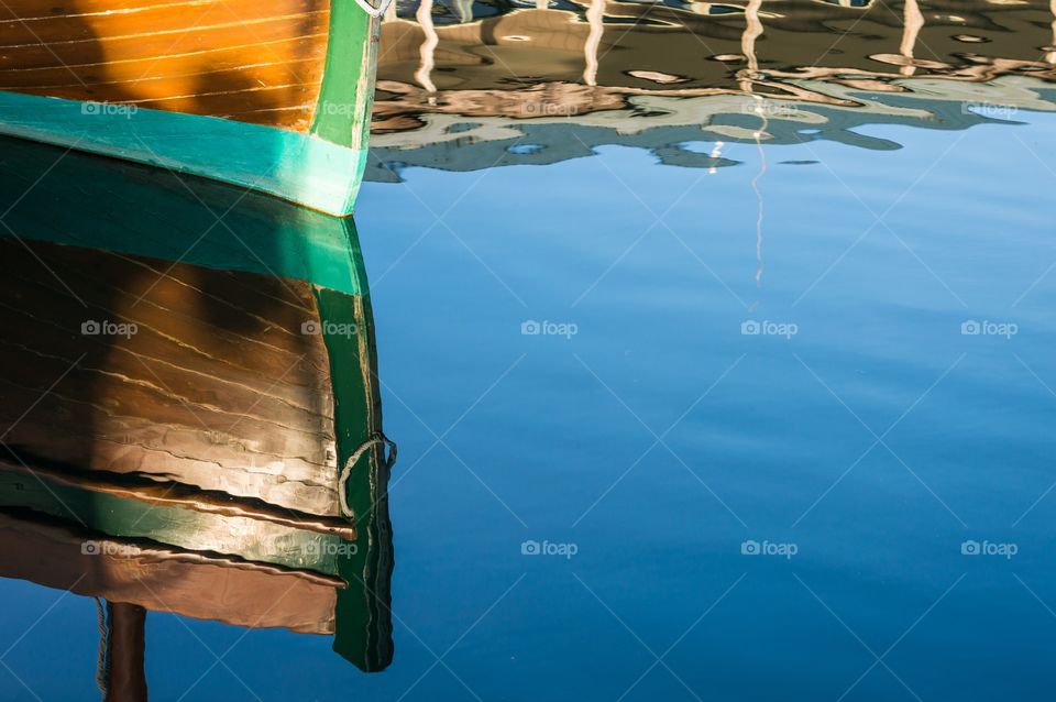 Wood boat reflection in the water.