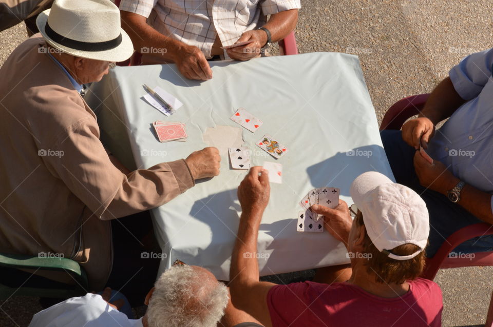 group of old men playing cards