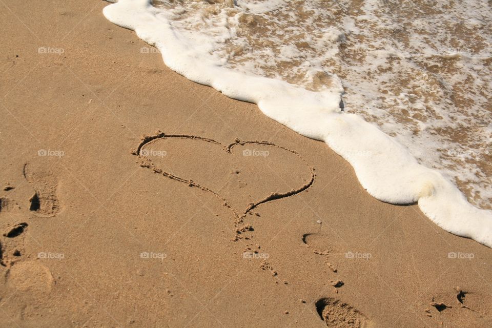 Love is written in the sand on the beach