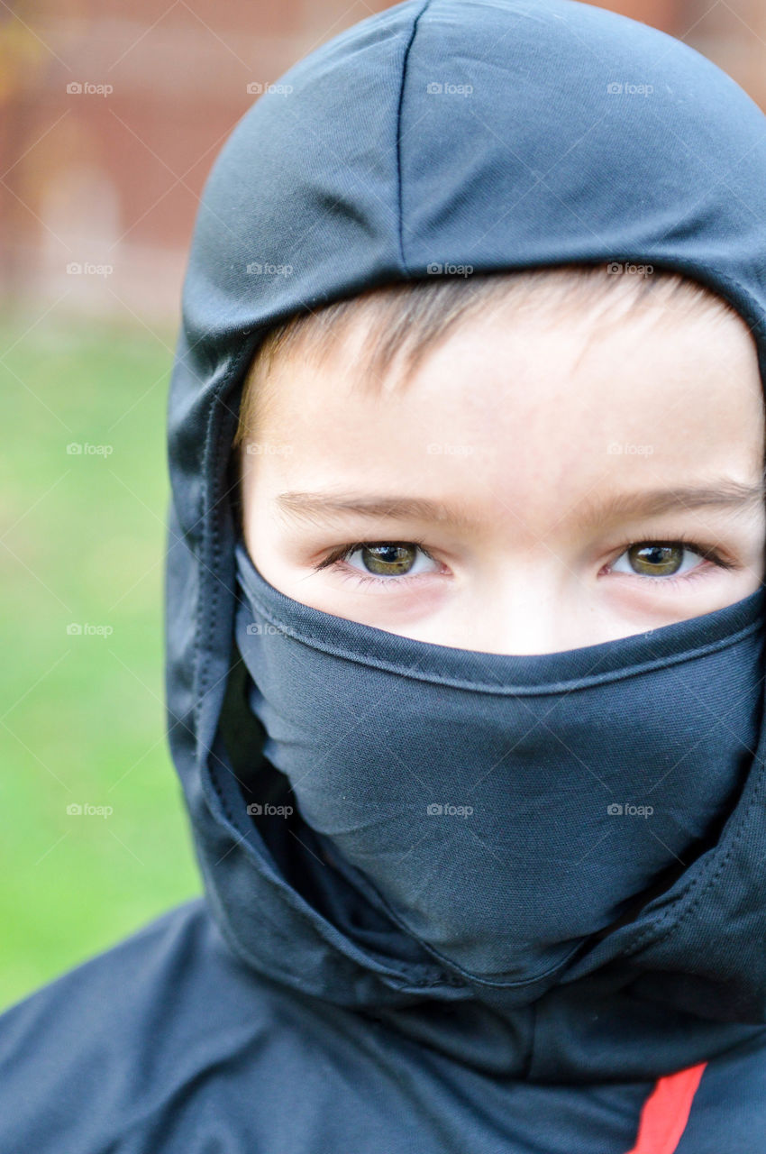 Close-up of a young boy's face in a ninja Halloween mask