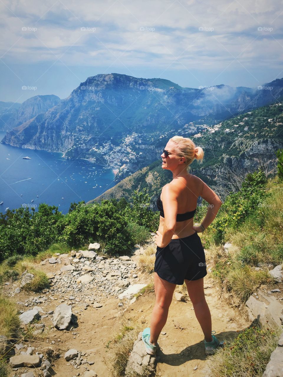 Woman standing on top of mountain near sea