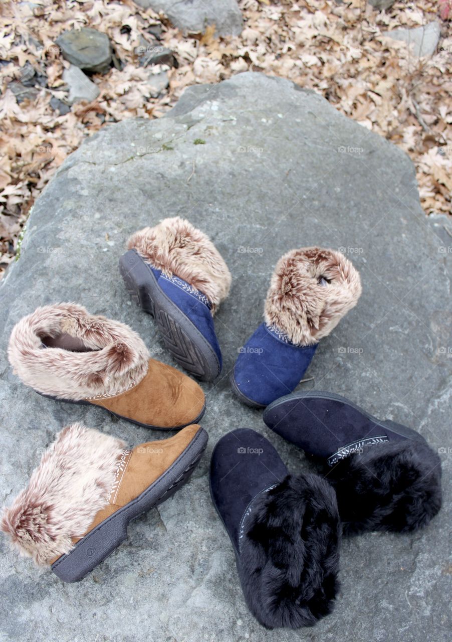 Circle of black,navy, and buckskin slippers on rock