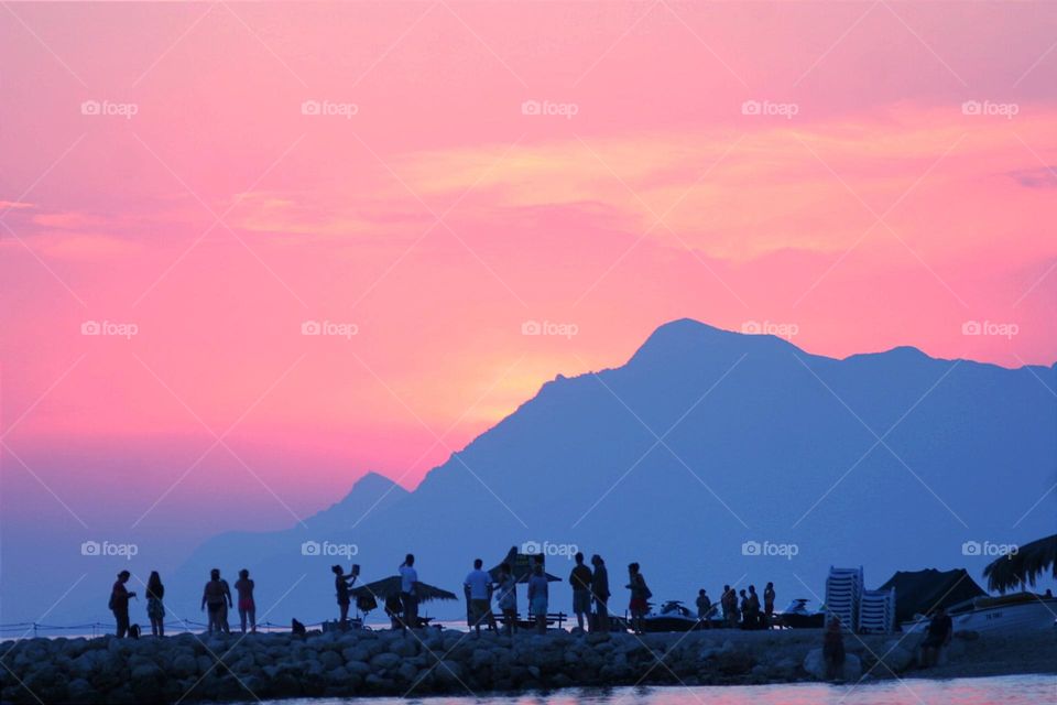 people relax against the backdrop of a fantastic landscape with a magnificent sunset