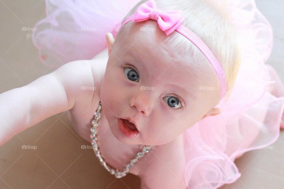 infant girl in a pink tutu with bright blur eyes