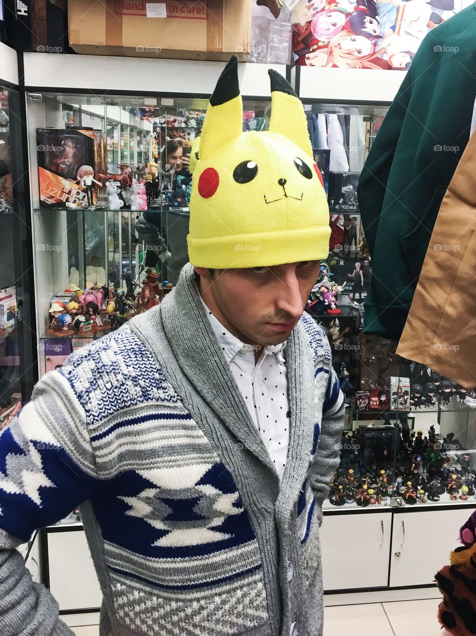 Man posing in anime store in pikachu hat