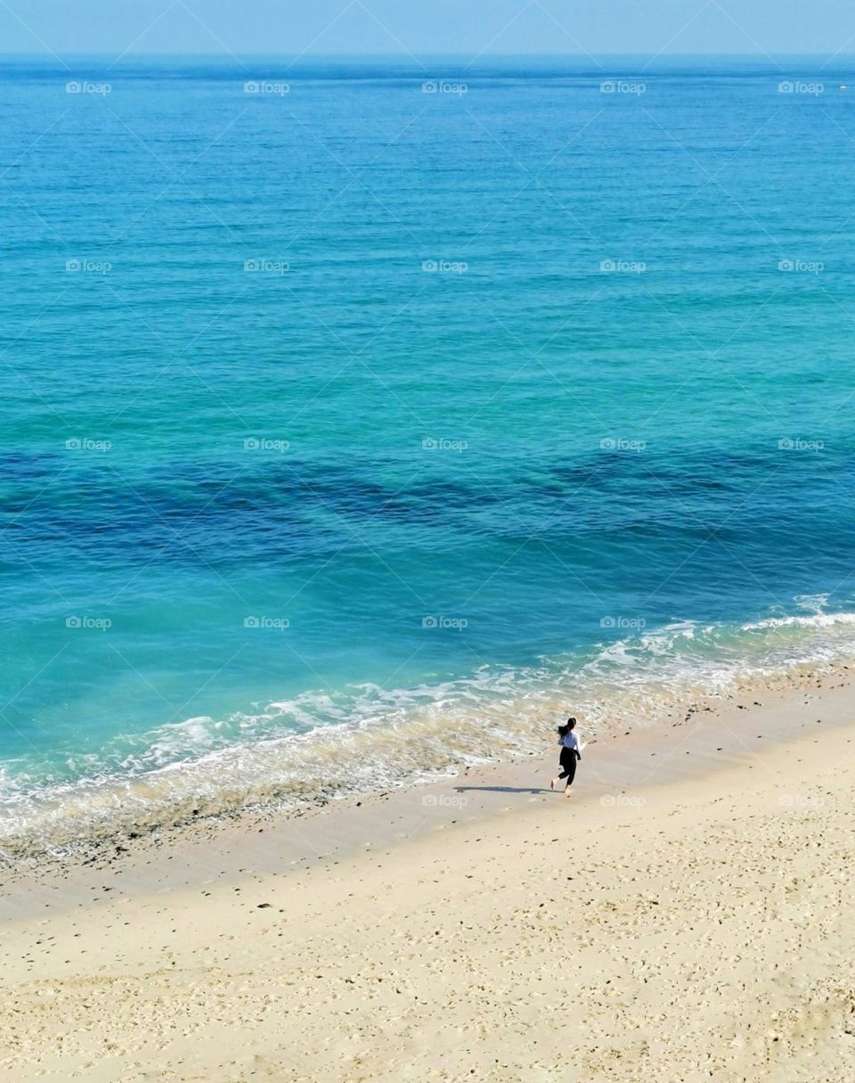 Blue sea, baby blue colour. Healthy life style. Woman and sea.