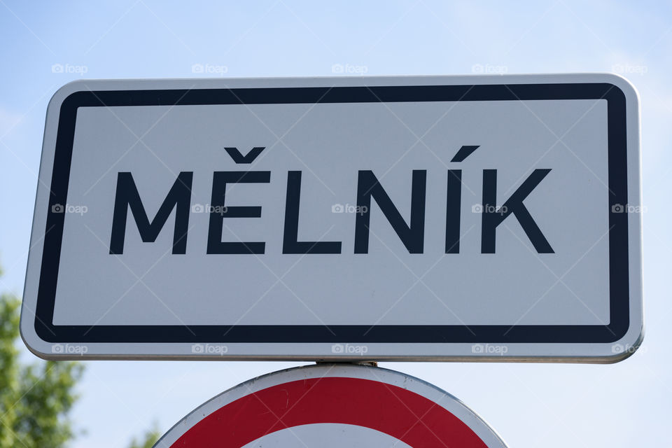 Melnik town entry sign on top of a traffic sign on sunny summer day in Melnik, Czech Republic.