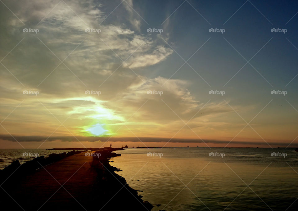 beautiful sunset by the breakwater port pier