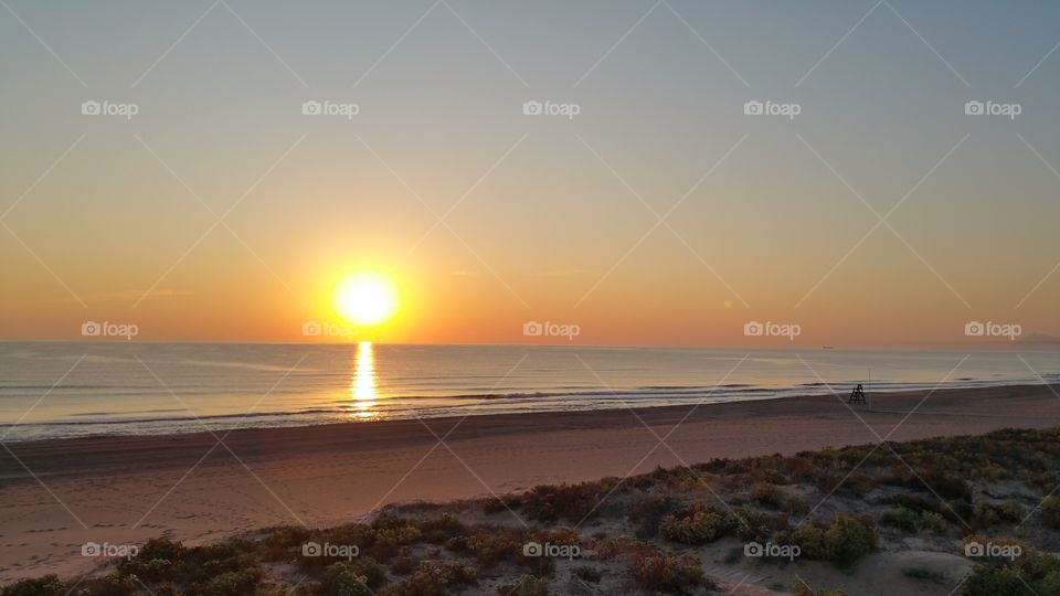 The rising sun at an empty beach.