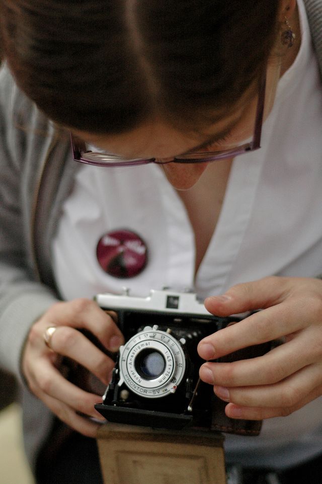 Woman holding old camera. Young woman holding old film camera