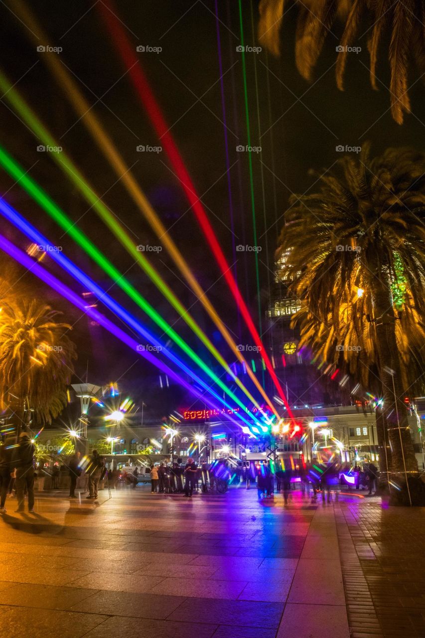 San Francisco Pride 2023 laser light display of the pride flag colors illuminating the sky in front of the Ferry Building on the Embarcadero