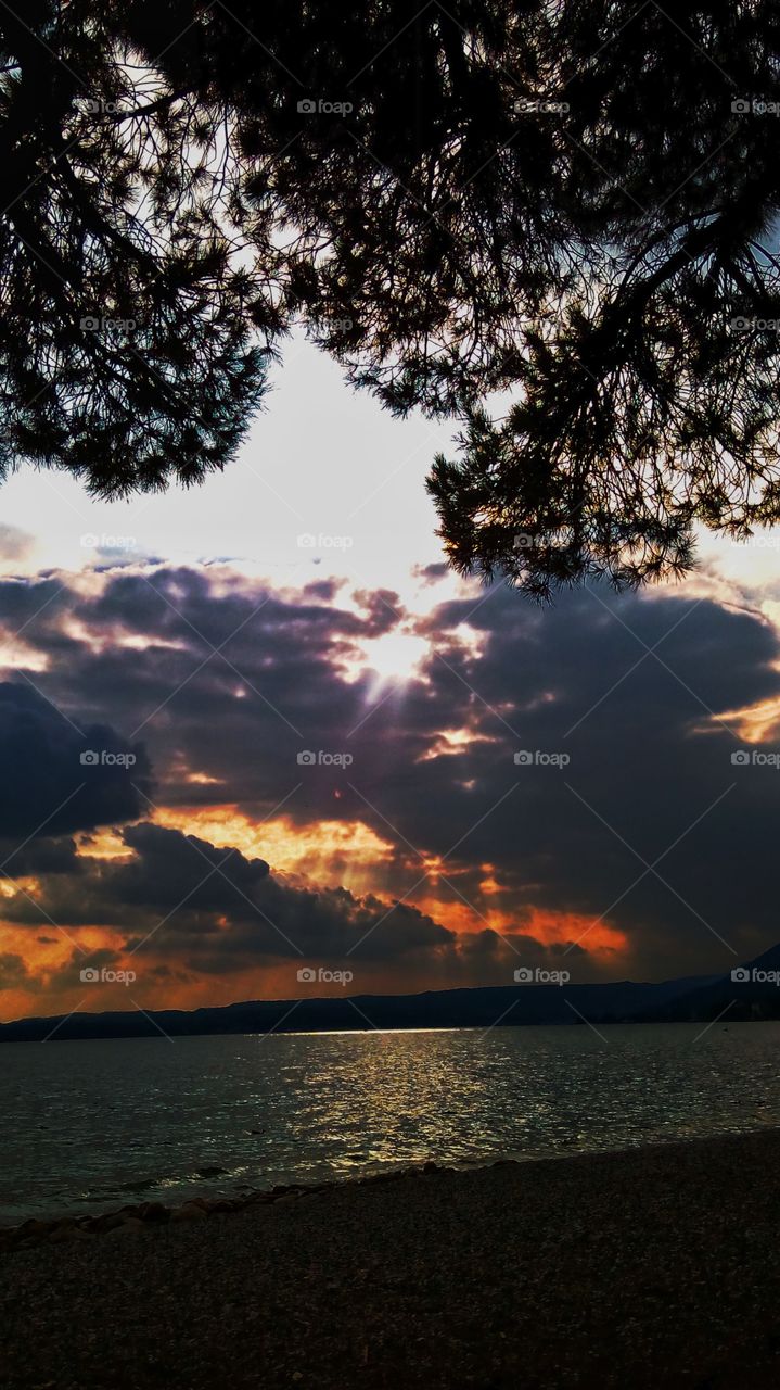 Cloudy and breathtaking sunset at the Garda Lake.