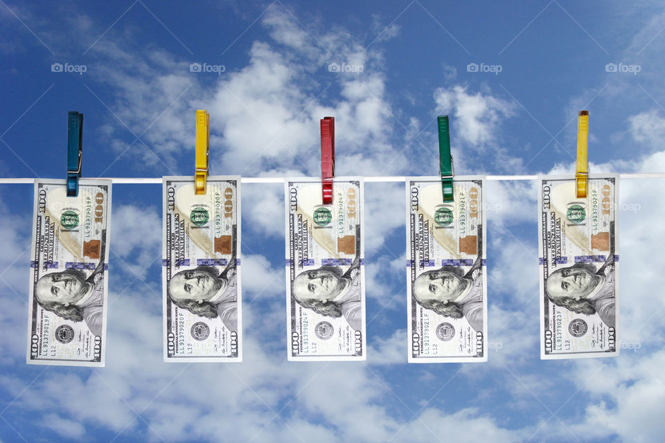 dollars dry on a rope against the blue sky