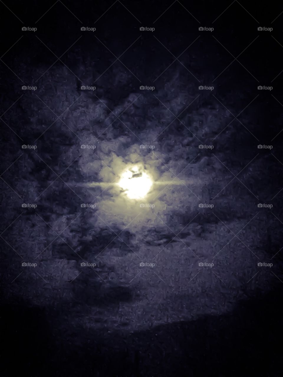 Eerie clouds pass over a magnificently bright full moon 