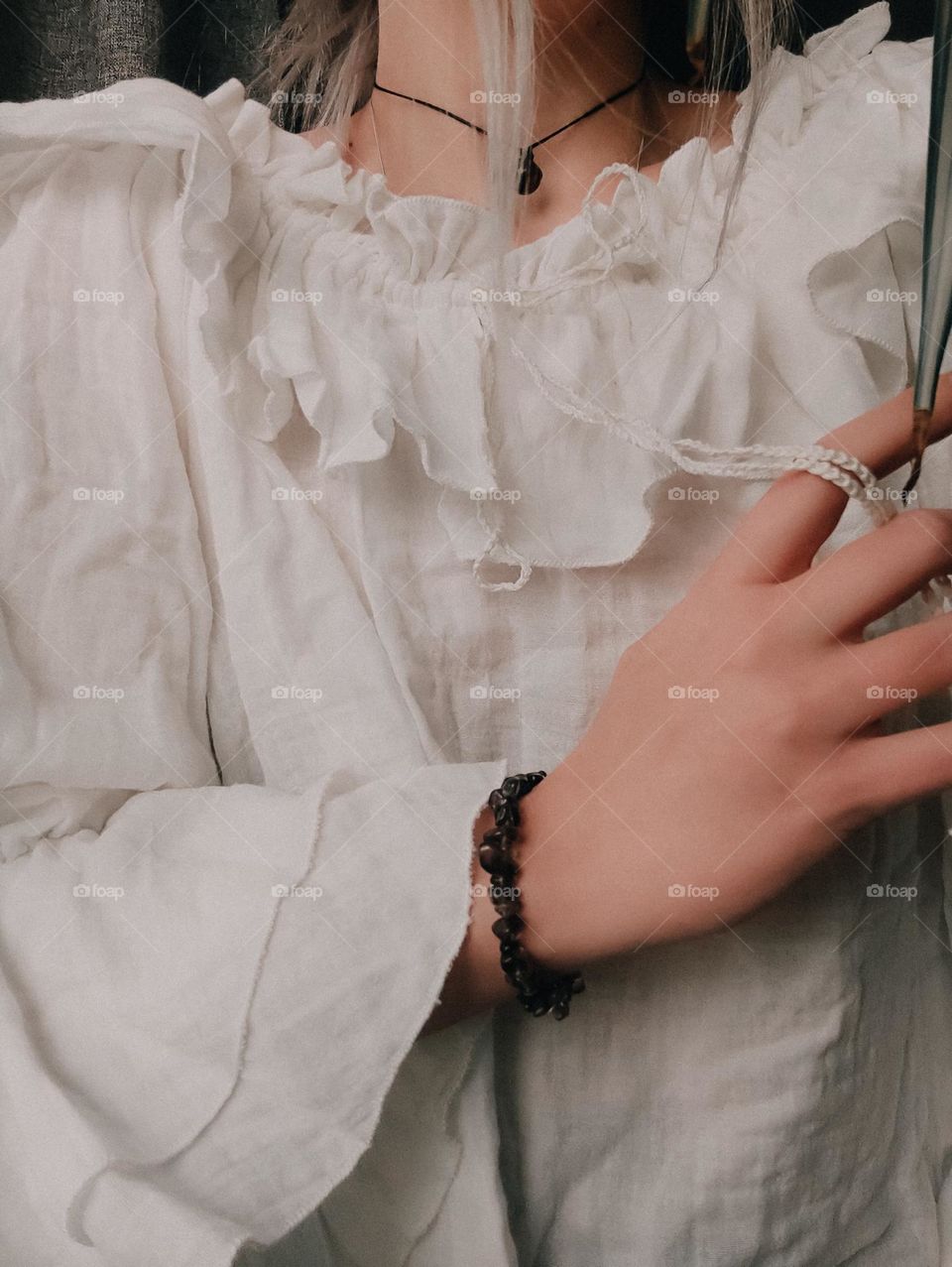 Woman in vintage white ruffle blouse, hand, stone chocker and bracelet, women's fingers, boho style
