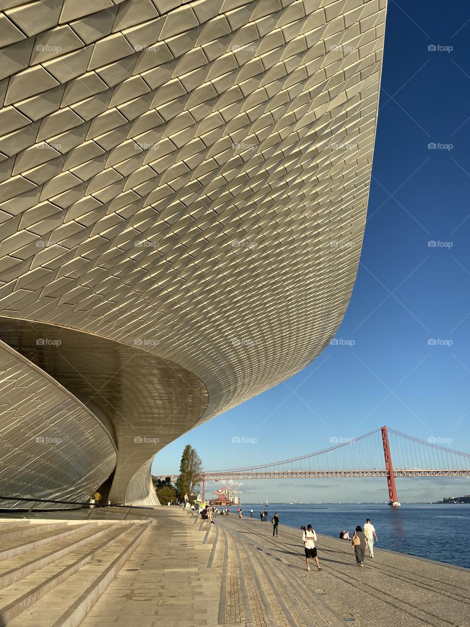 Modern building in lisbon by the bridge against blue sky
