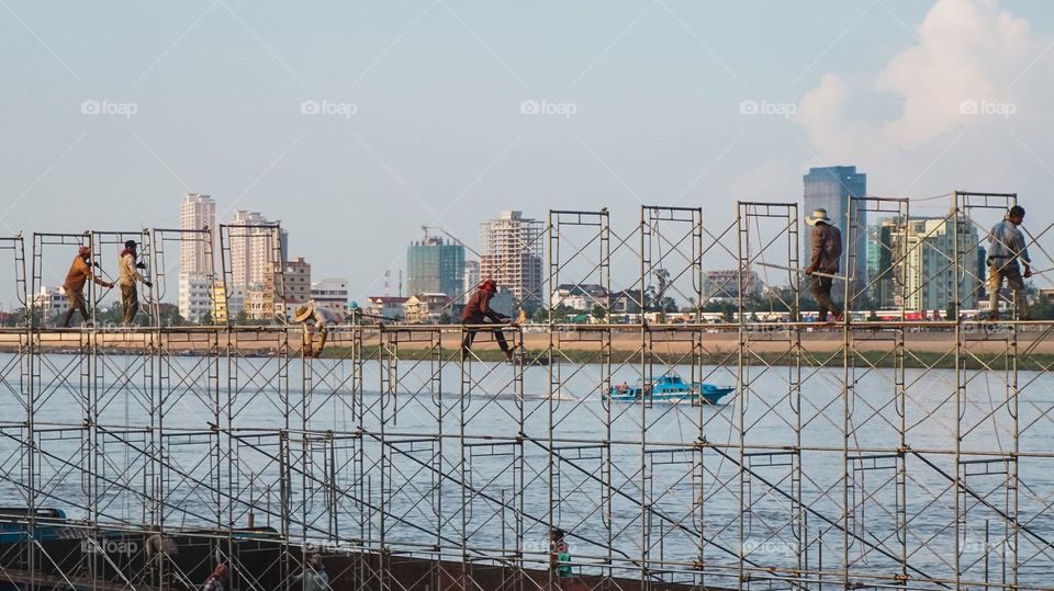 Men disassembling one of the many large floats from the river festival in Phnom Penh, Cambodia 