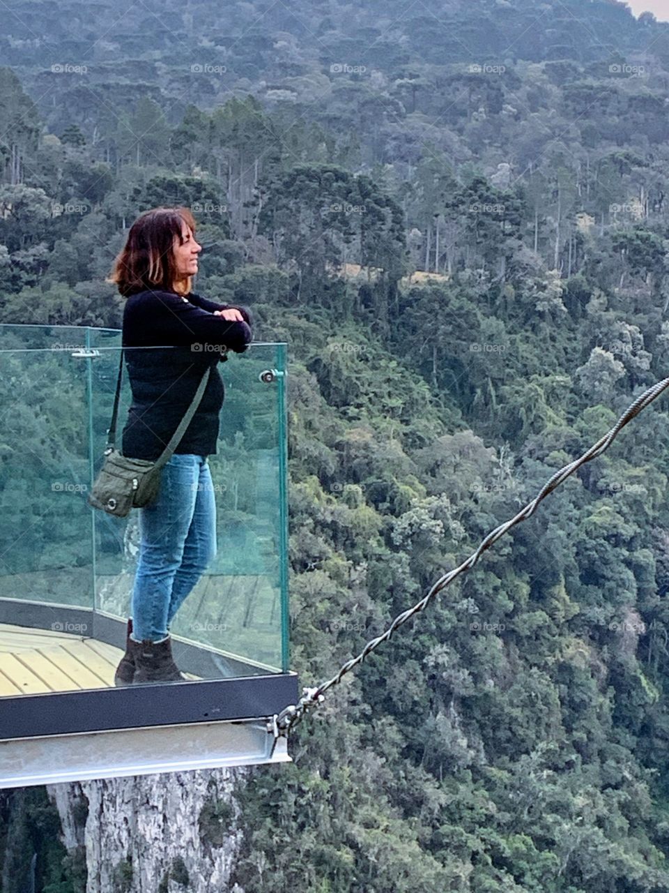 Woman admiring a landscape at the top of the mountain.