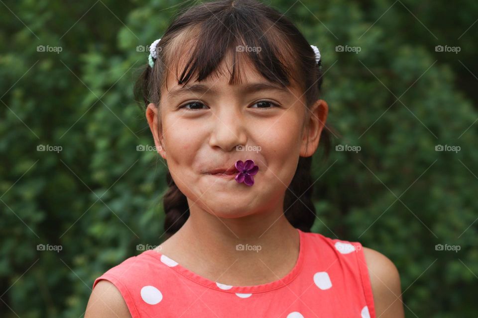 Energetic portrait of a happy girl in a red polka dot dress