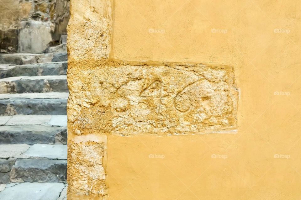 Rectangular corner stone in the old town of Menton, France from 1646.