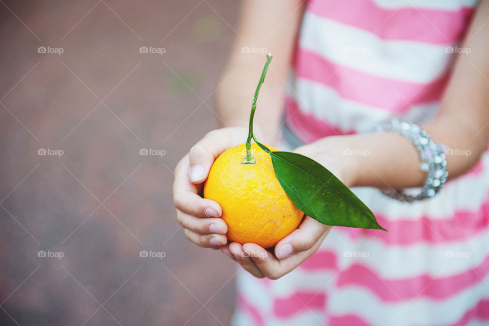 Hands holding a fresh orange